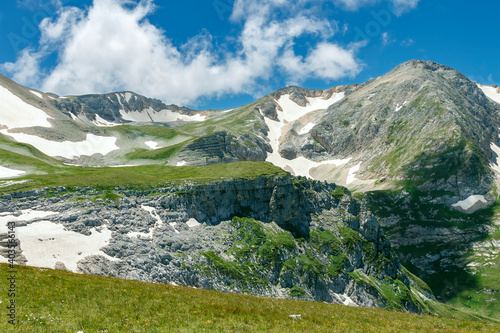 Landscape with a mountain peak in the clouds and huge white boulders in the foreground
