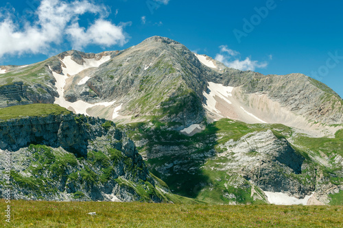 Landscape with a mountain peak in the clouds and huge white boulders in the foreground

