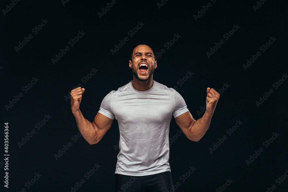 Muscular athlete shouting in joy - obrazy, fototapety, plakaty 