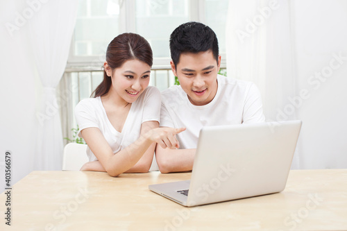 A young Couple Using Laptop at Home