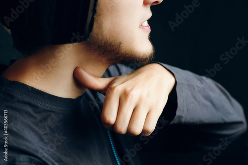 Mad gamer having violent look, making threatening sign, gesturing with index finger at his neck as if cutting throat. Why video games are bad for kids © Konstantin Savusia