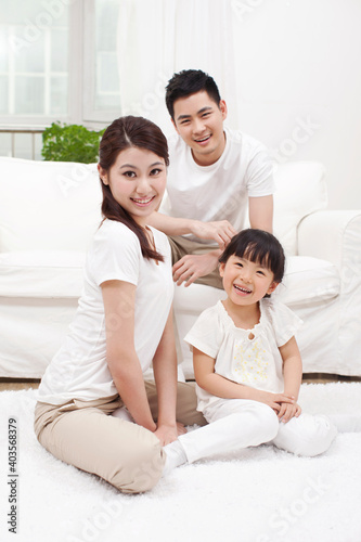 A happy family of three sitting in couch  © eastfenceimage