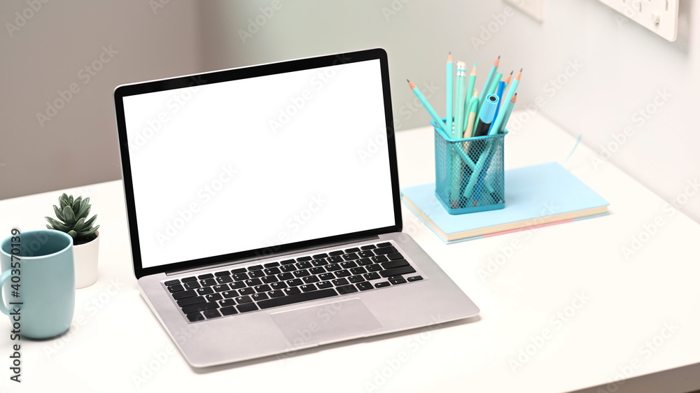 Mock up laptop computer with blank screen, notebook, stationery and coffee cup on creative designer workspace. Mock up laptop computer with blank screen, notebook, stationery and coffee cup on creative designer workspace.