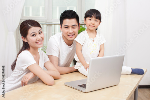 Little girl using laptop with her parents