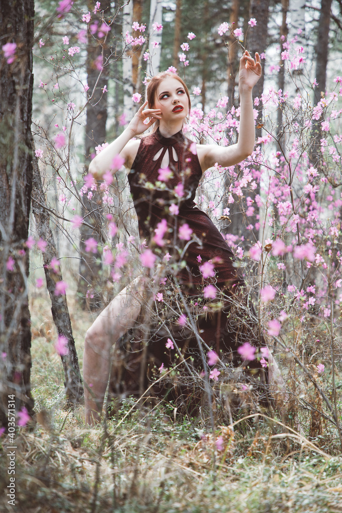 Japanese-style girl in a flowering forest among pink flowers in spring Japanese-style girl in a flowering forest among pink flowers in spring