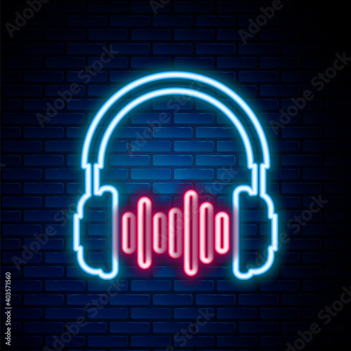 Glowing neon line Headphone and sound waves icon isolated on brick wall background. Concept object for listening to music, service, communication and operator. Colorful outline concept. Vector.