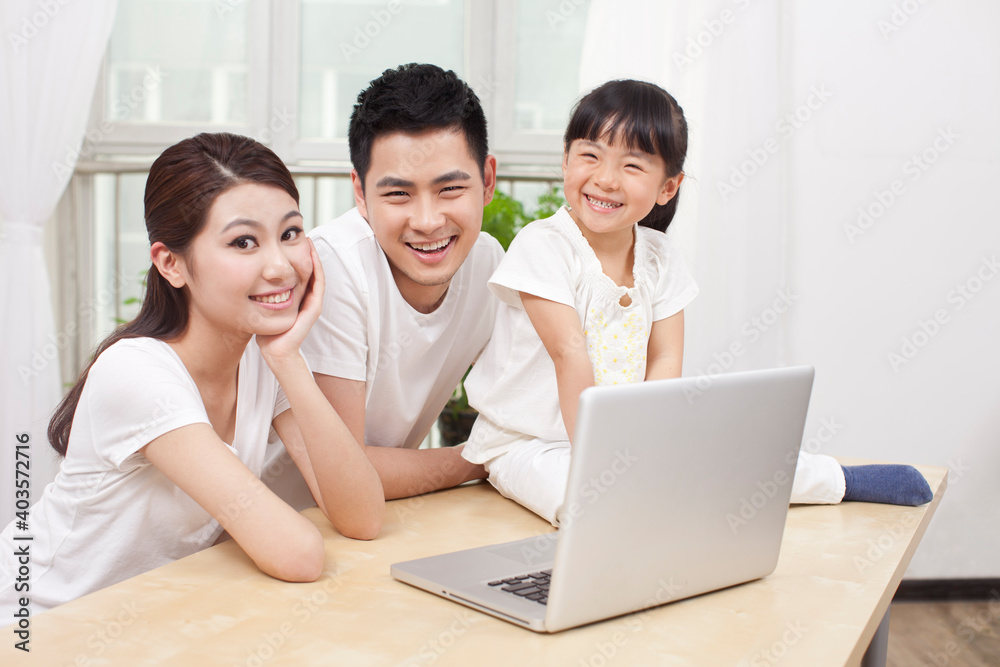 Little girl using laptop with her parents Little girl using laptop with her parents