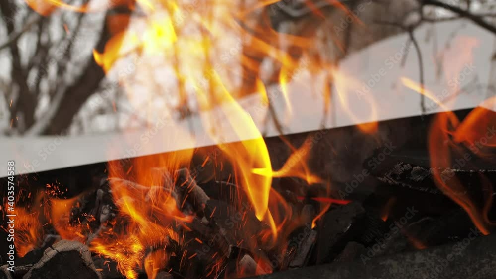 burning fire in the grill on the snow. warm tongues of fire on a cold day. burning fire in the grill on the snow. warm tongues of fire on a cold day.