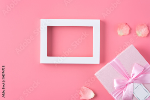 Valentine's Day design concept background with pink petals and gift box. © RomixImage