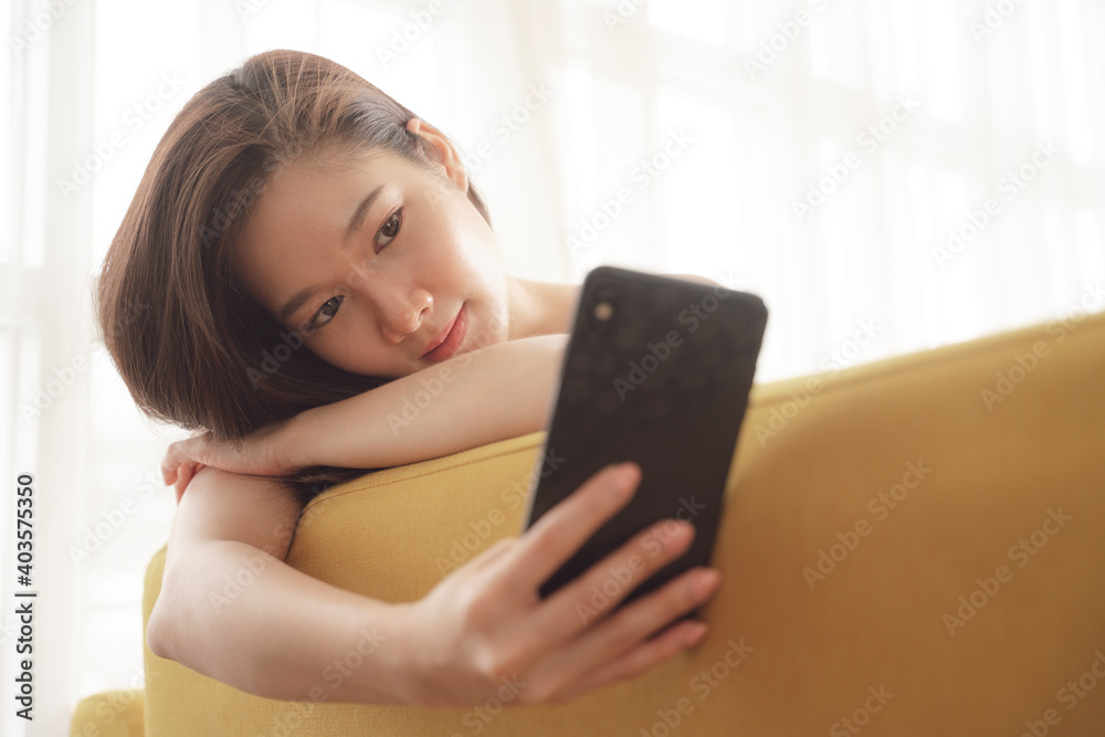 Asian beauty woman using smartphone and taking selfie on a couch at home. Asian beauty woman using smartphone and taking selfie on a couch at home.