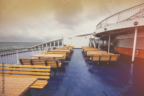 Fotografiet Empty benches on ferry deck in rainy weather