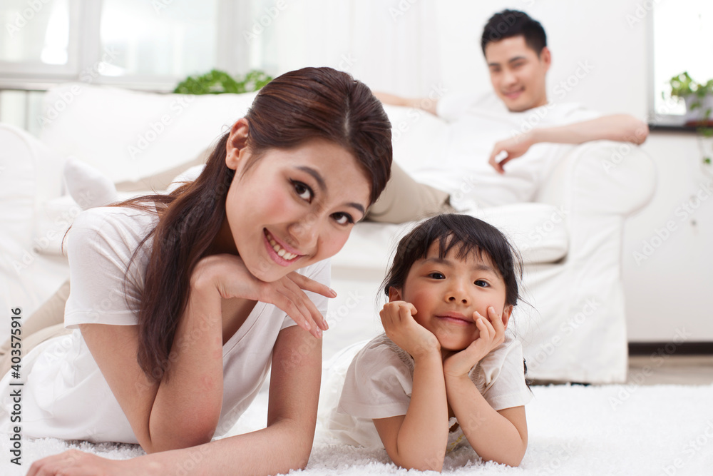 A happy family of three sitting in couch A happy family of three sitting in couch