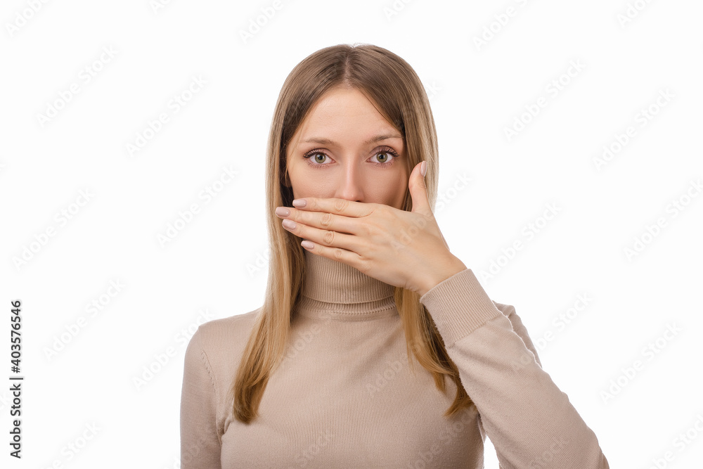 Frustrated blond girl is covering mouth with hand not willing to disclose something important. Keep a secret Frustrated blond girl is covering mouth with hand not willing to disclose something important. Keep a secret
