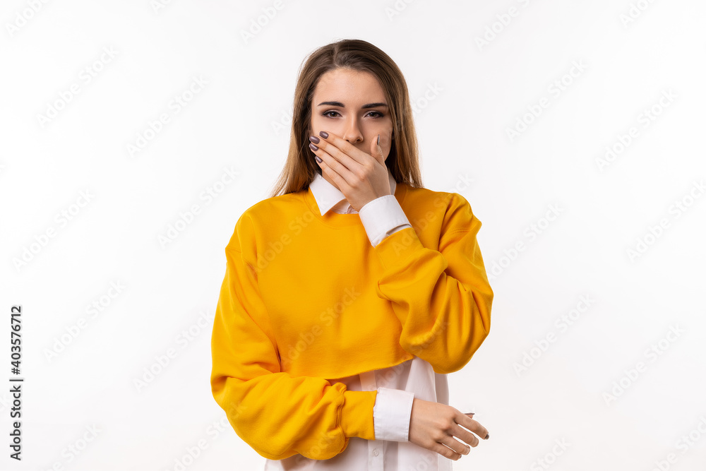 Frustrated brunette girlis covering mouth with hand not willing to disclose something important. Keep a secret Frustrated brunette girlis covering mouth with hand not willing to disclose something important. Keep a secret
