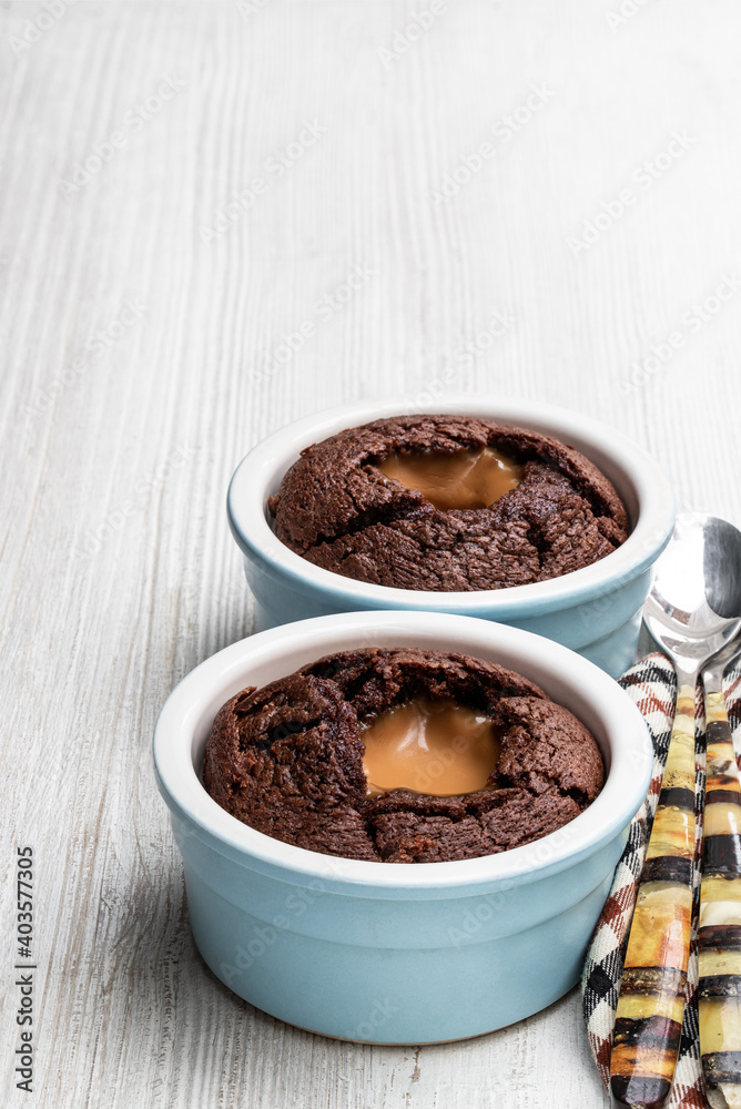 Hot chocolate lava cake in clay pot on wooden table Hot chocolate lava cake in clay pot on wooden table