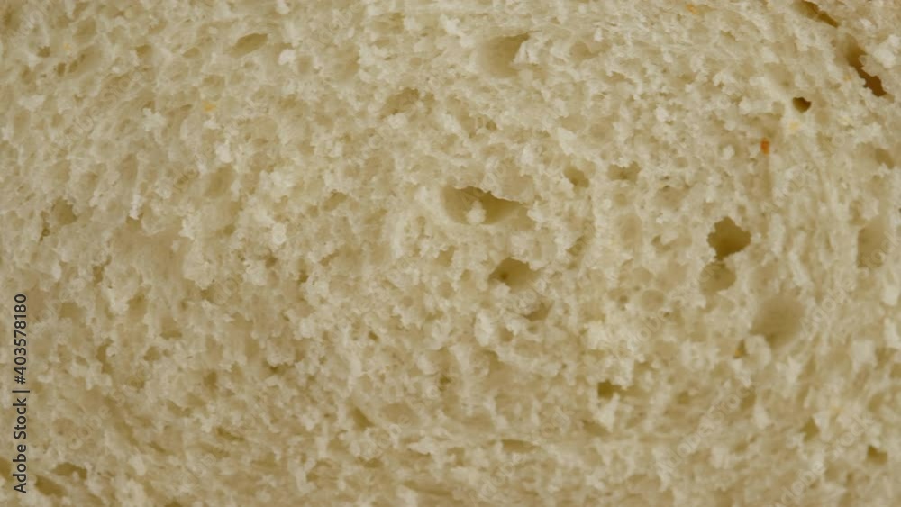 Camera movement. Close-up of hot wheat bread lies on a lattice on a light table. White bread is prepared in a professional bakery from flour, water, oil, salt. Camera movement. Close-up of hot wheat bread lies on a lattice on a light table. White bread is prepared in a professional bakery from flour, water, oil, salt.