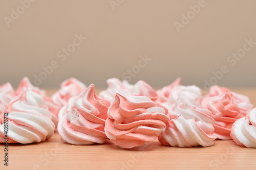 Pink and white meringues on a wooden table