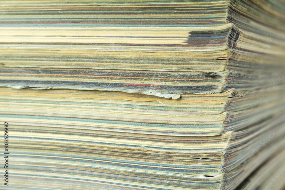 Stack of old shabby magazines. Side view with bokeh effect. Stack of old shabby magazines. Side view with bokeh effect.