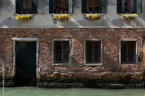 Building facade details with a water door on a Venetian canal, Italy