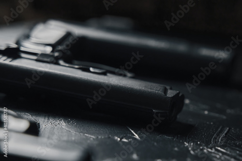 Close-up of handguns on black table. Dangerous firearms. Criminal or police arsenal.