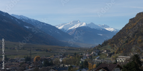 Picturesque view to the valley of Naturns in South Tyrol in autumn, in the background the snow-covered mountains, blue sky with clouds, no people