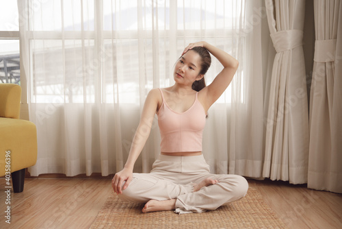 Healthy asian beauty woman doing yoga on wooden mat at home.