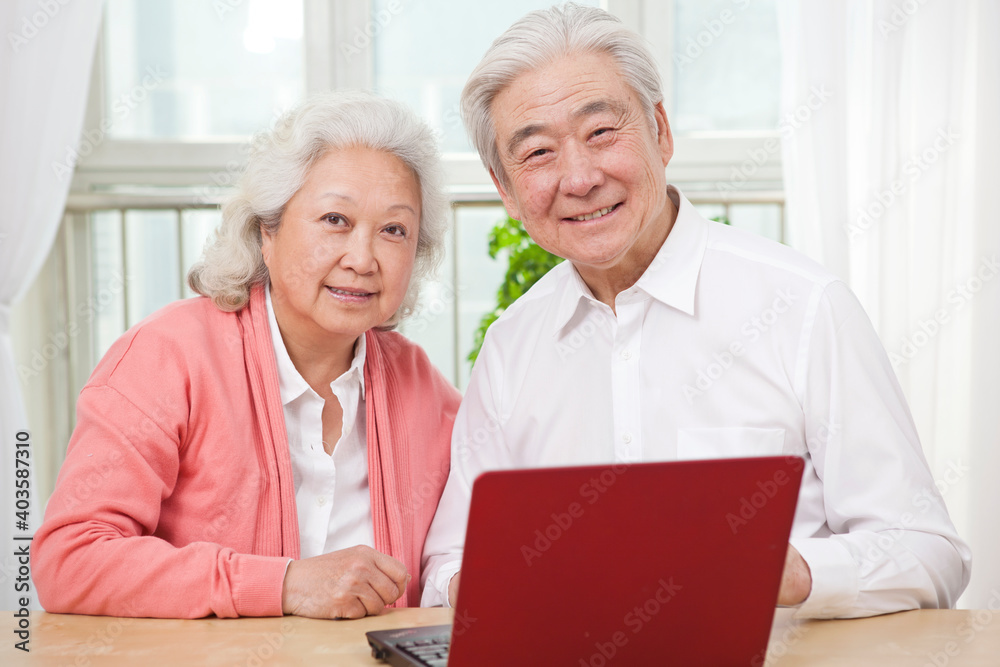 The happy old couple are using laptops The happy old couple are using laptops