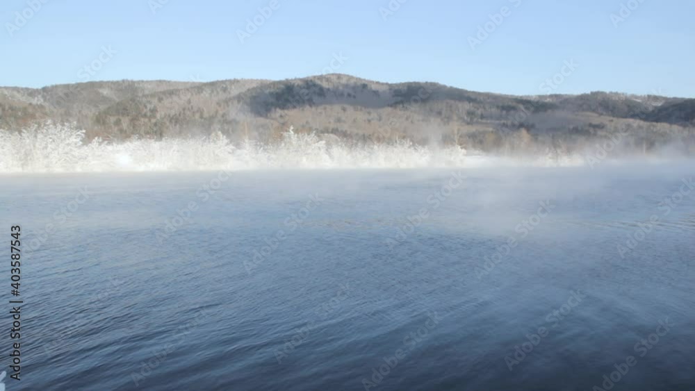 there is fog over the winter river and on the other bank the trees are covered with frost there is fog over the winter river and on the other bank the trees are covered with frost