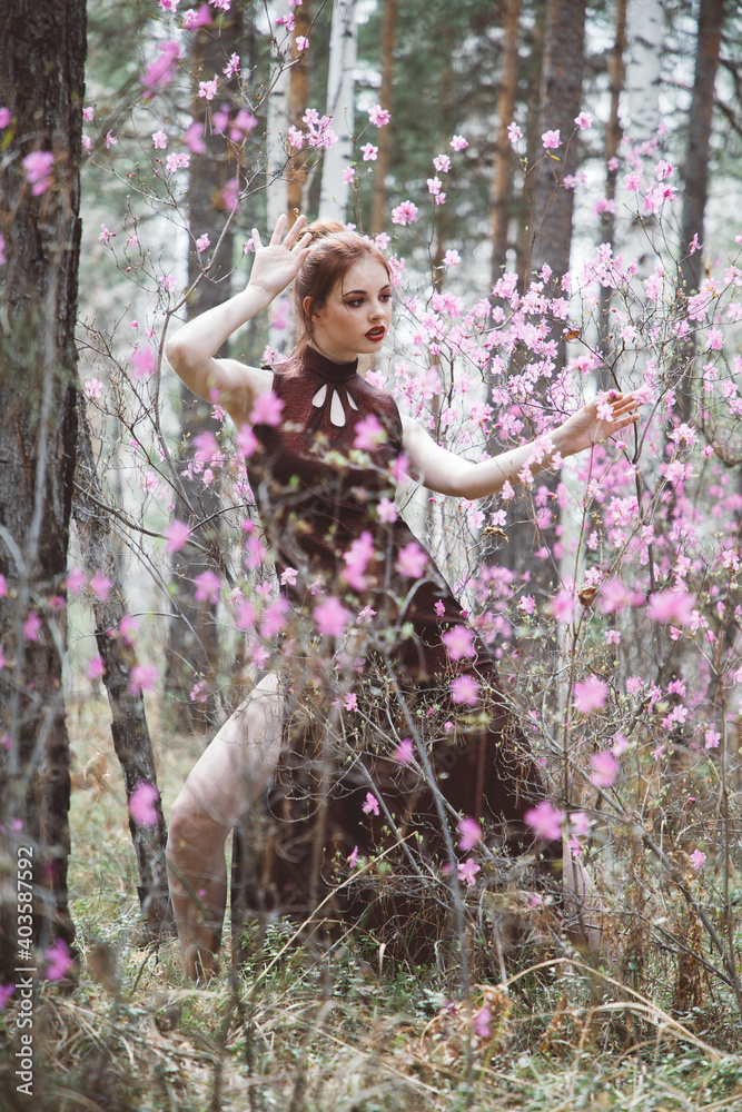 Japanese-style girl in a flowering forest among pink flowers in spring Japanese-style girl in a flowering forest among pink flowers in spring
