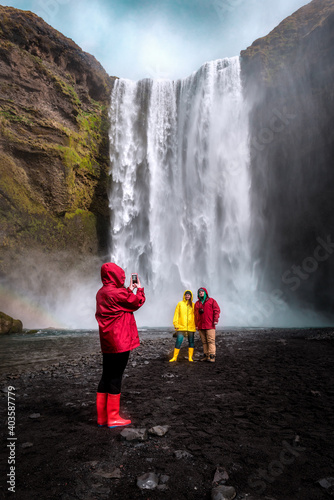friends are photographed near the waterfall