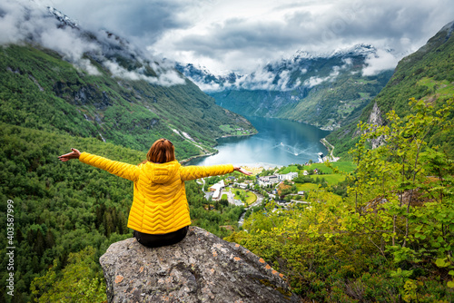 Happy woman in yellow over Geiranger fjord photo