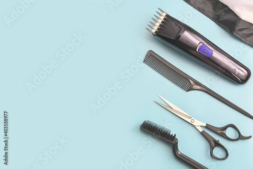 barber tools on blue background. hair clipper, comb, scissors and brush. man hair stylist equipment. male beauty care. home hair cut tools. hairdresser electric machine.