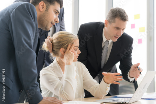 Group of business people are working together and discussing about the project in the meeting room at the office. They are concern project timeline. Business woman shows the report to her boss