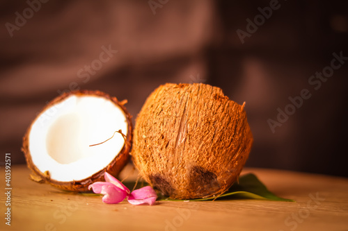 half coconut with green leaves wooden on background,hd footage of coconut milk and half coconut on wooden,selective focus on subject,