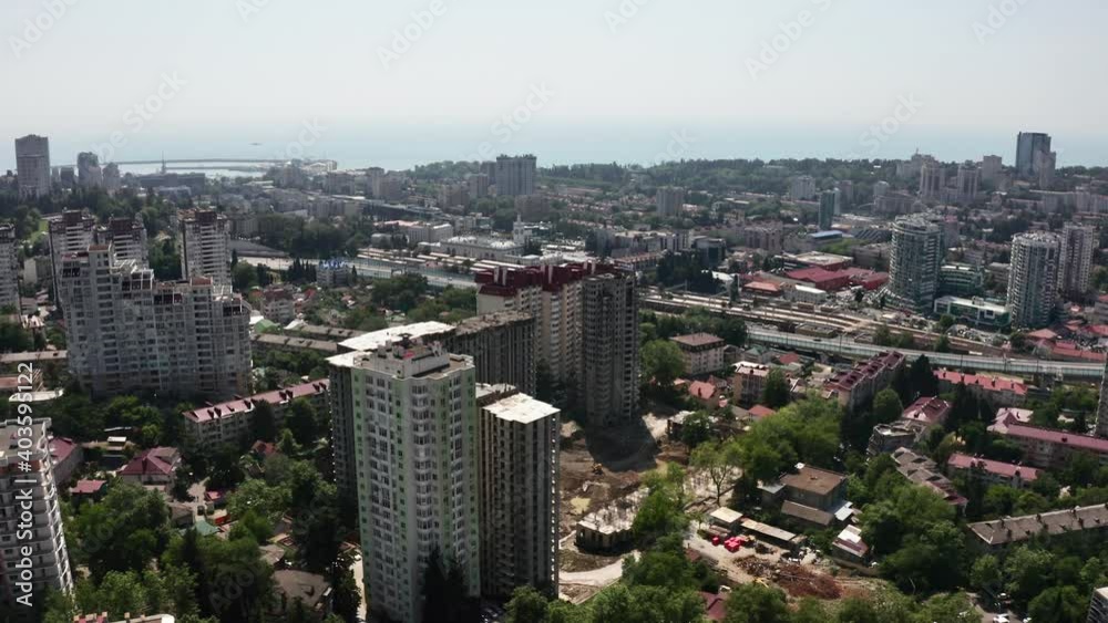 Sochi city at sunny day with architecture district downtown infrastructure surrounded by sunlight sea pier and sky. Aerial drone view amazing modern touristic town resort at seashore nature scenery. Sochi city at sunny day with architecture district downtown infrastructure surrounded by sunlight sea pier and sky. Aerial drone view amazing modern touristic town resort at seashore nature scenery.