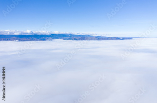 Aerial drone shot of flying above clouds