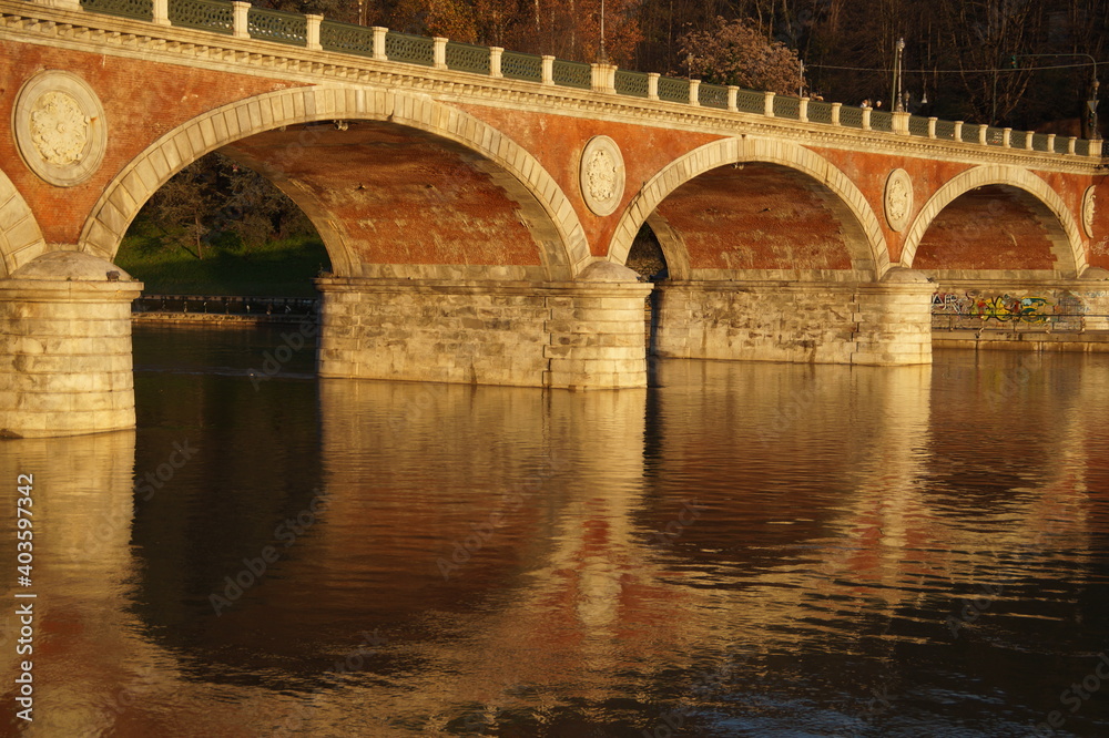 Italy: arched bridge over the river in autumn

