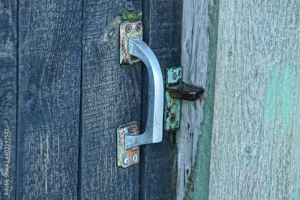 white old door handle with lock on the gray wooden door white old door handle with lock on the gray wooden door