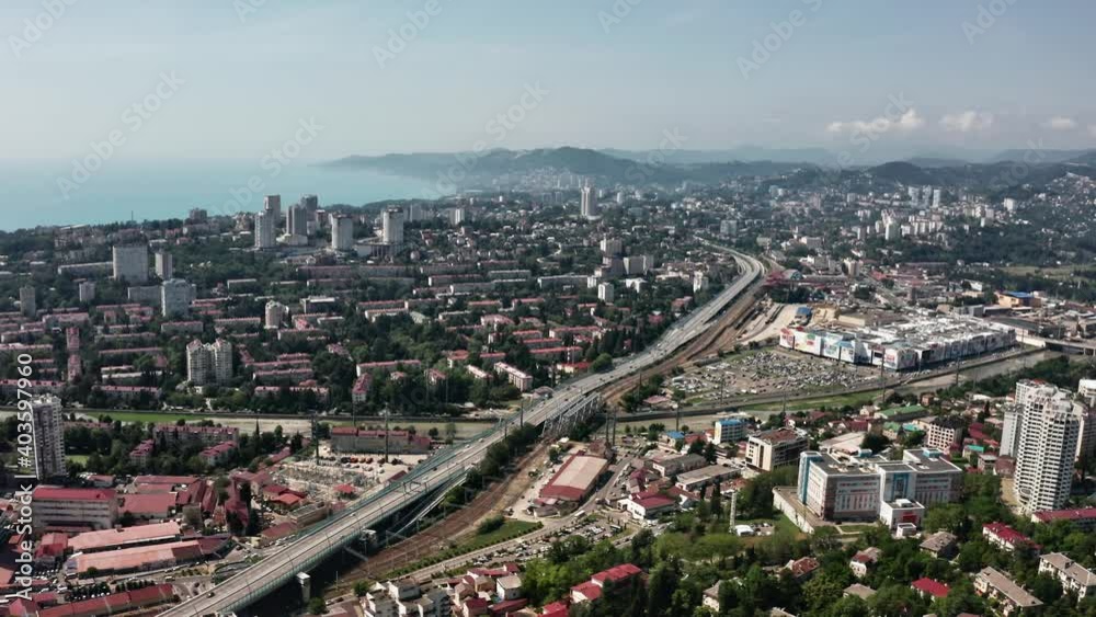 Aerial video shooting. Panoramic view of the city center of Sochi. High building on a background of green mountains. No people. Blue clear sky. camera's moving Aerial video shooting. Panoramic view of the city center of Sochi. High building on a background of green mountains. No people. Blue clear sky. camera's moving