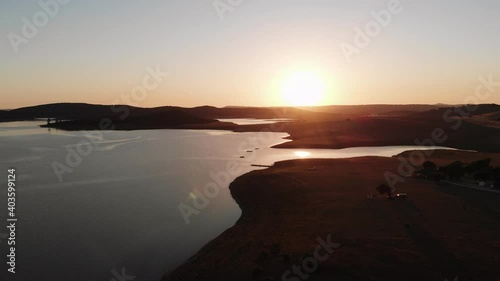 Beautiful Wakana lake silhouette during golden hour with the sun setting in the background - Aerial Panoramic shot