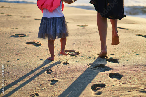 Footprints in the sand. The feet of the mother and child walk along the shore. Summer memories. Plzha by the sea. High quality photo