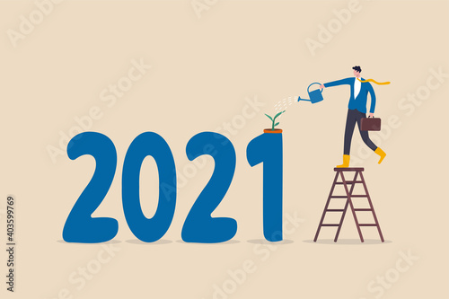 Year 2021 economic recovered from COVID-19 Coronavirus outbreak, business grow up from government stimulus policy concept, businessman watering seedling plant grow from year number 2021.