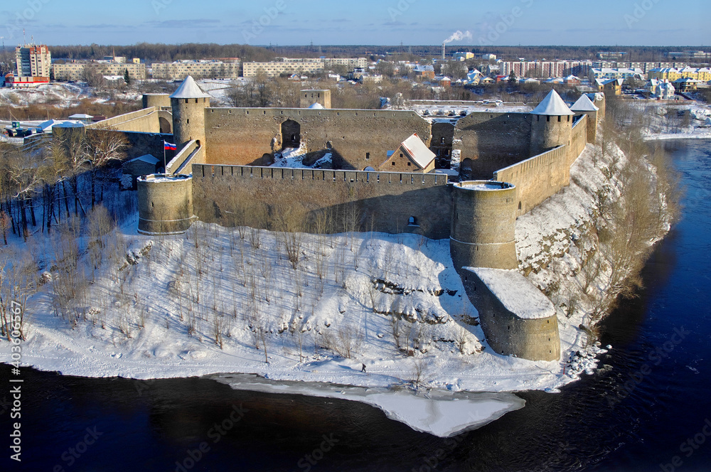 Top-down view of snow-covered Ivangorod fortress and vicinity of Ivangorod town on the Russian-Estonian border (Narova river) taken from opposite placed Narva fortress in a sunny winter day