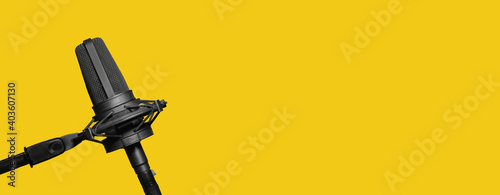 Professional microphone isolated on yellow background, radio, podcast or website banner with copy space photo