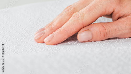 A woman reads a book written in Braille.