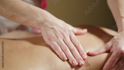 Close-up massage of female hands of the back in the area of the scapula.