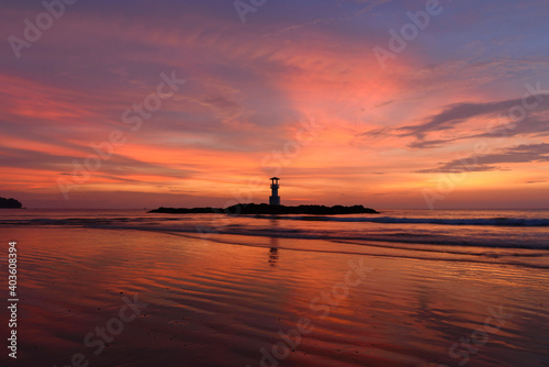The scenery of the silhouette Khao Lak lighthouse in sunset time with the dramatic twilight sky at Phang-Nga, Thailand.