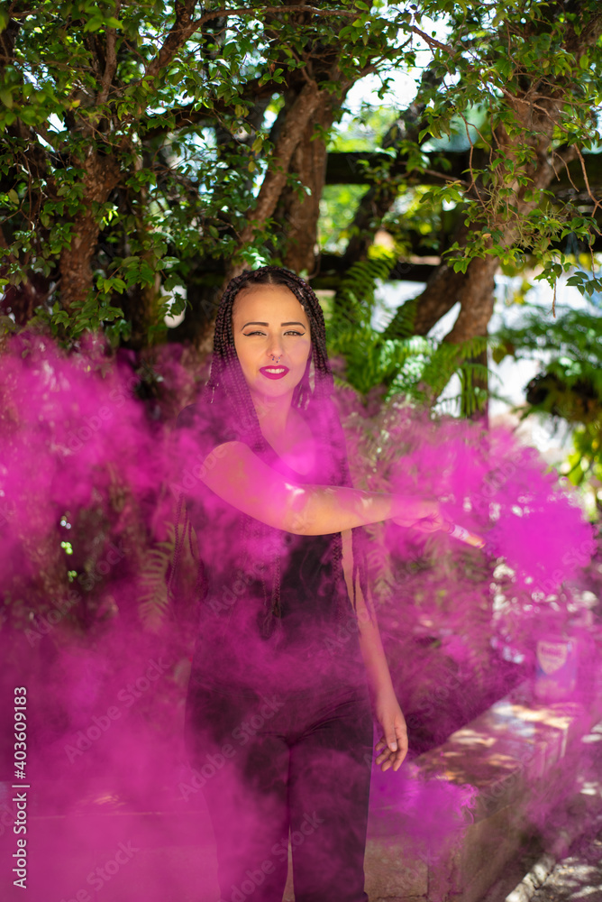 Happy girl, beautiful happy girl with colored smoke stick with natural light, selective focus.