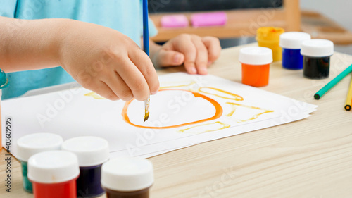 Closeup of little toddler boy drawing picture with colorful paint using brush. Child education at home during self isolation and lockdown. Concept of art and creativity of children