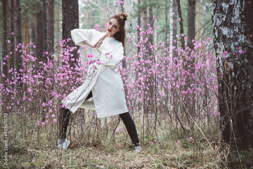 Japanese-style girl in a flowering forest among pink flowers in spring